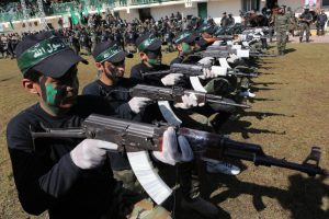 TO GO WITH AFP STORY BY MAI YAGHI (FILES) - A file picture taken on January 29, 2015, shows Palestinian youth showing their skills during a graduation ceremony as part of a training camp run by the Hamas movement in Khan Yunis, in the southern Gaza Strip. Some 17,000 teenagers and young adults passed out at a military parade organised by the Ezzedine al-Qassam Brigades in the south of the besieged territory, marking their completion of a week-long military training camp. AFP PHOTO / SAID KHATIB